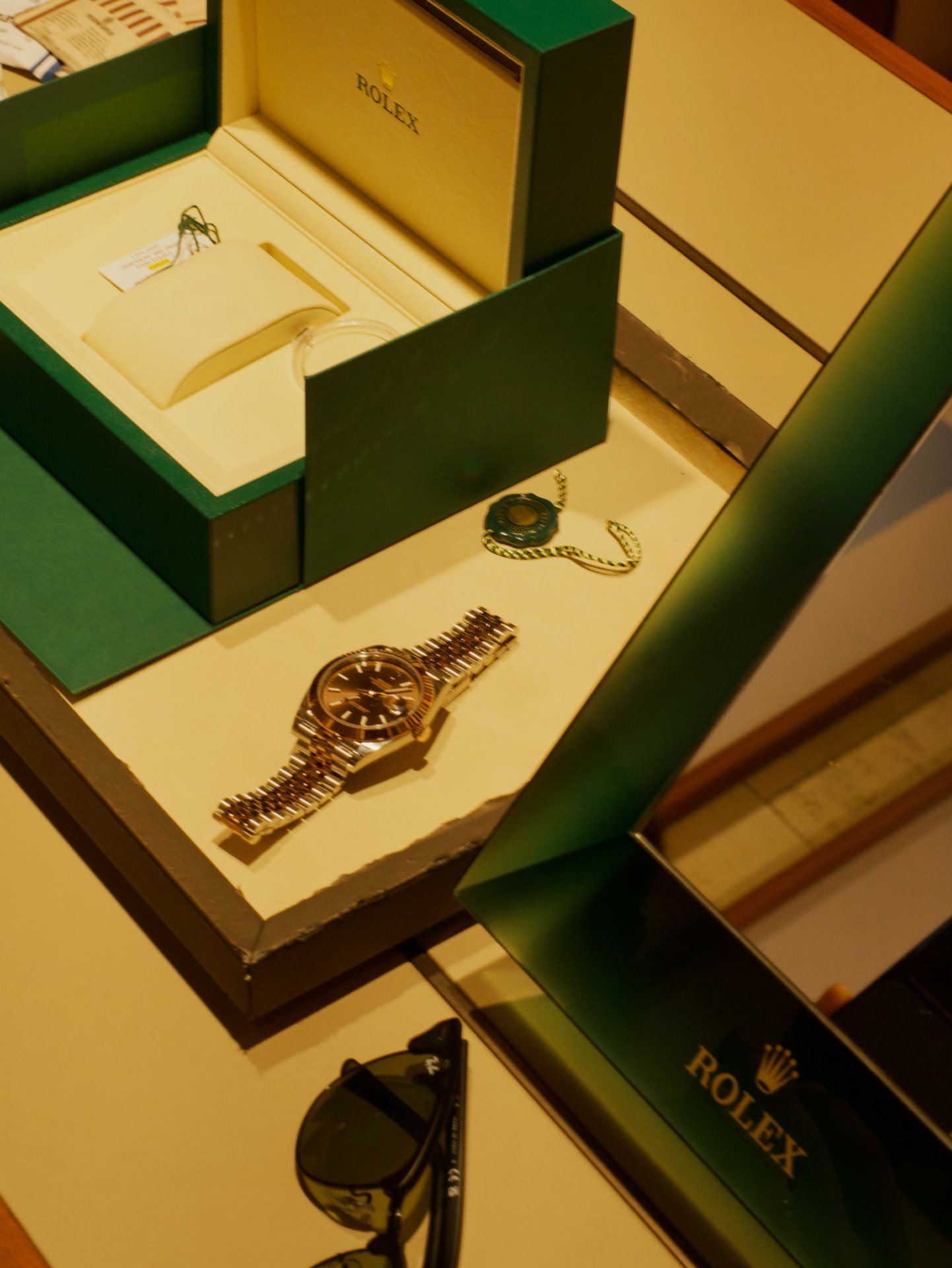 Rolex watch displayed beside its presentation boxes
